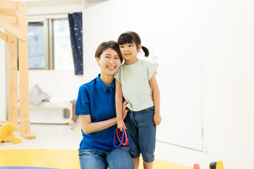 教室で子どもと並んで笑う職員